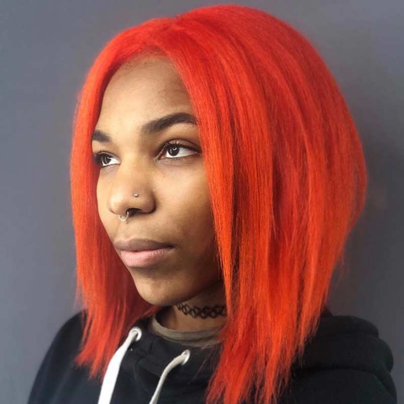 Young woman modeling bright orange hair dye and cut